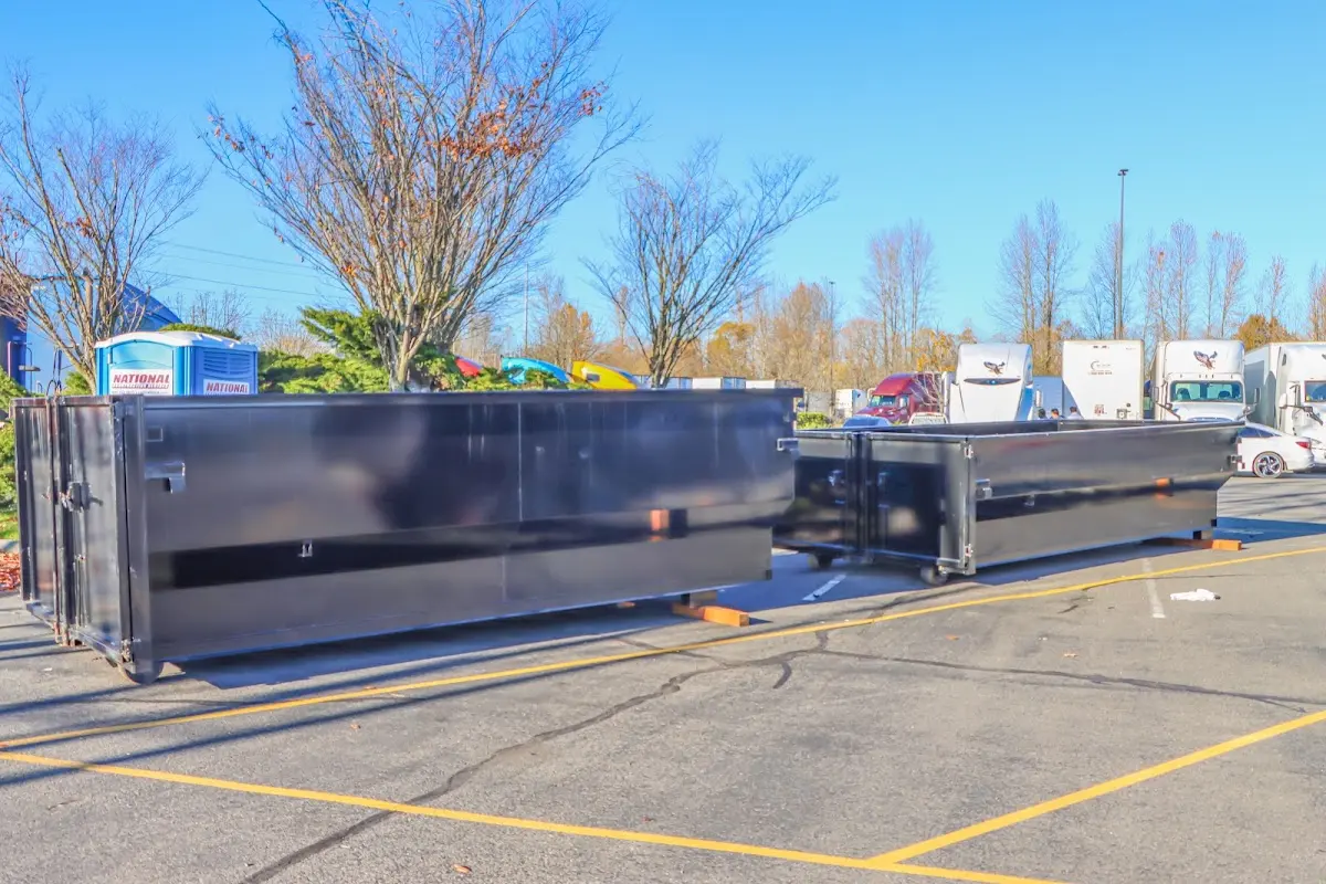 Professional dumpster rental service with roll-off container on residential driveway in Muscoy
